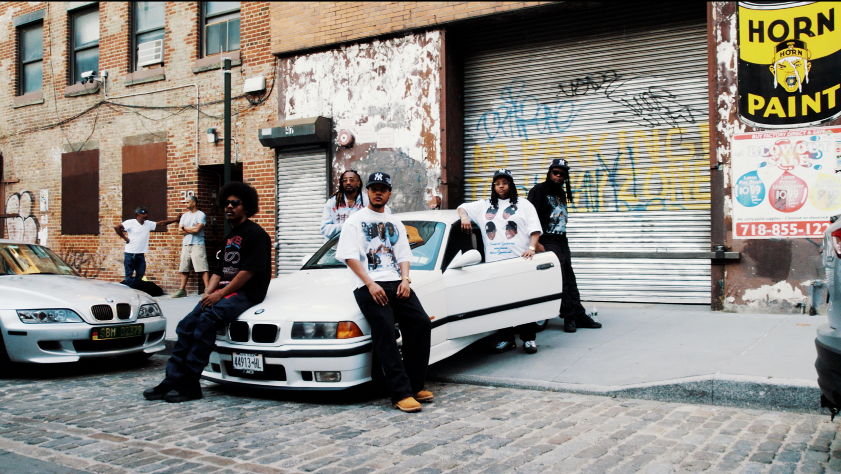 Crew posted on a Brooklyn block, white BMW, cobblestone street